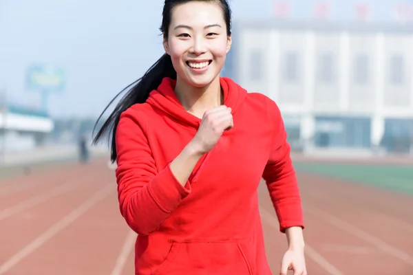 美丽的女运动员，在操场上跑向相机前面观 — 图库照片