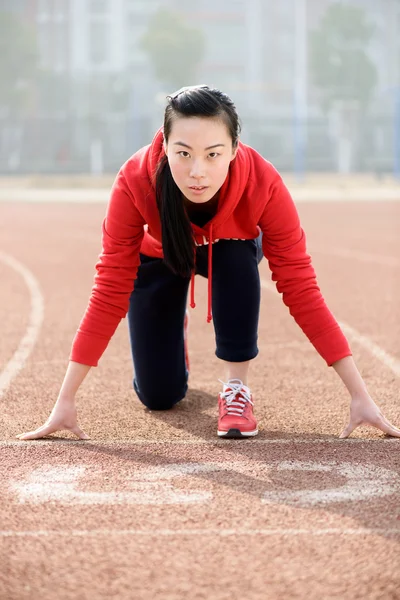 Athletic kinesisk kvinna i startposition på rätt spår — Stockfoto