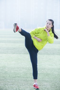 Parkta bir dövüş sanatları tekme gerçekleştiren jimnastik salonu elbise giymiş genç bir dişi