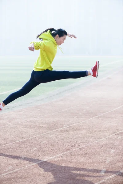 年轻漂亮的女人在操场上跳 — 图库照片