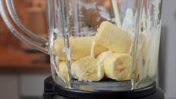 Ρίχνουμε γάλα αμυγδάλου στο μπλέντερ με μπανάνα σε φέτες, αργή κίνηση — Αρχείο Βίντεο