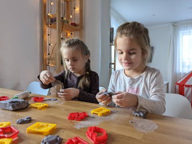 Küçük kızlar kilden bir şeyler yapıyor..