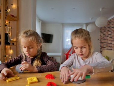 Küçük kızlar kilden bir şeyler yapıyor..