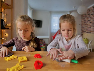 Küçük kızlar kilden bir şeyler yapıyor..