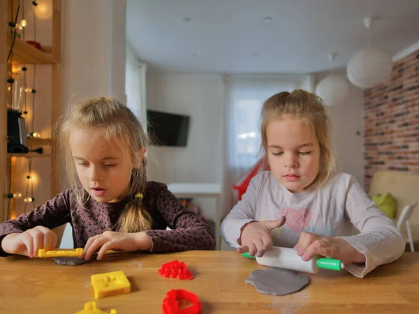 Küçük kızlar kilden bir şeyler yapıyor..