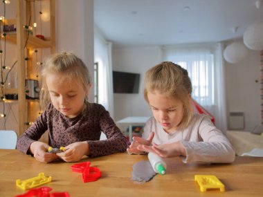 Küçük kızlar kilden bir şeyler yapıyor..