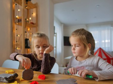 Küçük kızlar kilden bir şeyler yapıyor..