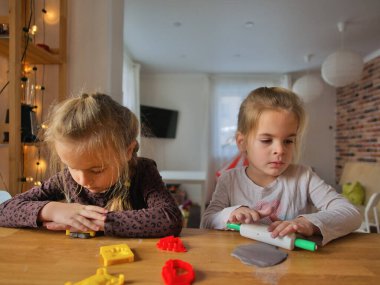 Küçük kızlar kilden bir şeyler yapıyor..