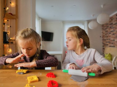 Küçük kızlar kilden bir şeyler yapıyor..