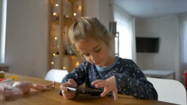 Girl prefers to play with a smartphone and not with dolls