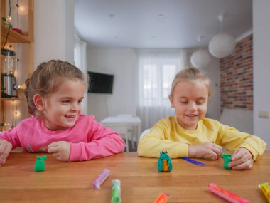 Küçük kızlar kilden bir şeyler yapıyor..