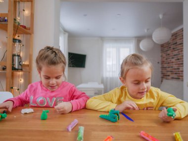 Küçük kızlar kilden bir şeyler yapıyor..