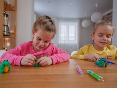 Küçük kızlar kilden bir şeyler yapıyor..