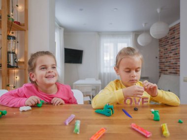 Küçük kızlar kilden bir şeyler yapıyor..