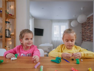 Küçük kızlar kilden bir şeyler yapıyor..