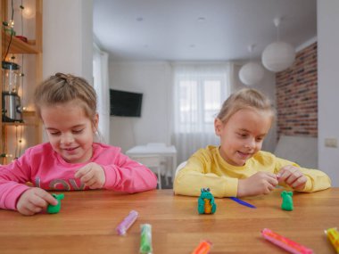 Küçük kızlar kilden bir şeyler yapıyor..