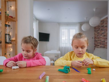 Küçük kızlar kilden bir şeyler yapıyor..