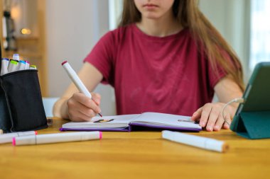 Çizim defterinde işaretleri çizen genç sanatçı kız