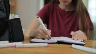 Çizim defterinde işaretleri çizen genç sanatçı kız