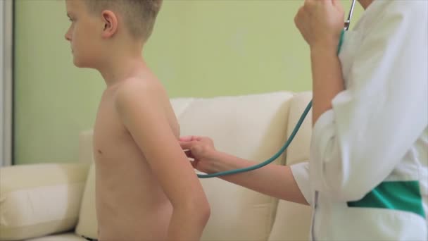 Kobieta pediatra ze stetoskopem diagnozującym małego chłopca — Wideo stockowe