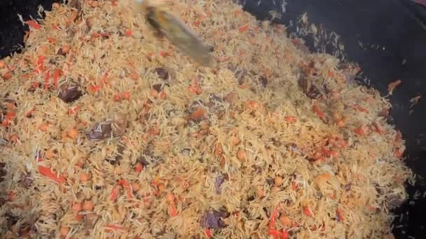 Close-up view on big cauldron with traditional uzbek food - pilaf — Stock Video