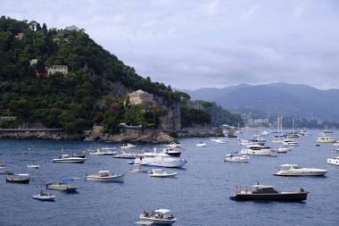 Bir kalenin doğal manzarası ve Portofino 'nun doğal bir yaprak yayı ve Akdeniz' deki teknelerin olduğu renkli evleri.