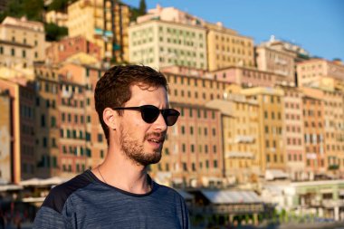 Camogli Körfezi 'nde güneş gözlüklü genç bir adamın portresi.