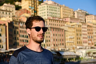 Camogli Körfezi 'nde güneş gözlüklü genç bir adamın portresi.