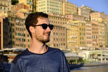 Camogli Körfezi 'nde güneş gözlüklü genç bir adamın portresi.