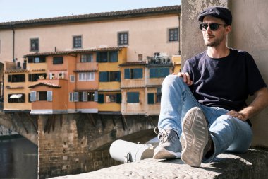 Floransa, Toskana, İtalya 'nın Ponte Vecchio' sunda güneş gözlüklü ve bereli bir adamın portresi.