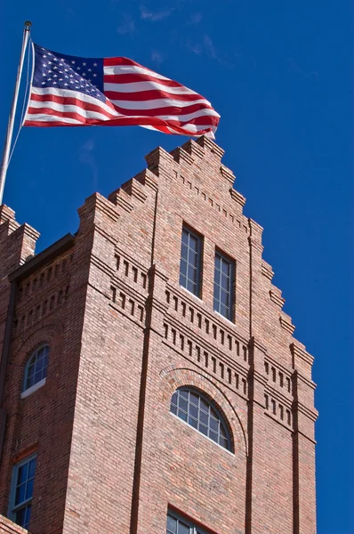 Régi tégla épület, repülő az amerikai zászló — Stock Fotó