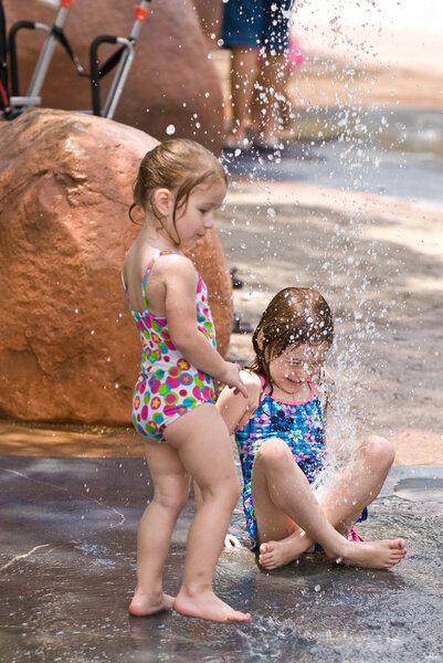 Две юные сестры играют вместе в воде
