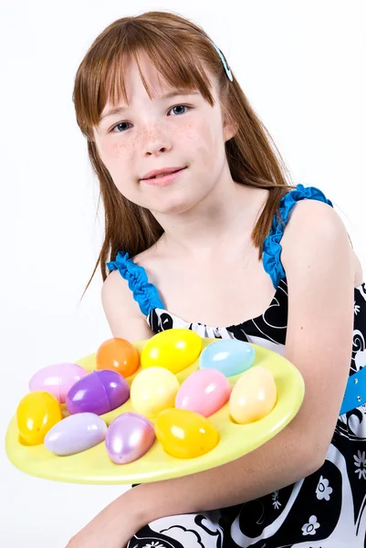 年轻的女孩子举行复活节彩蛋一盘，如果她将它们提供给某人 — 图库照片