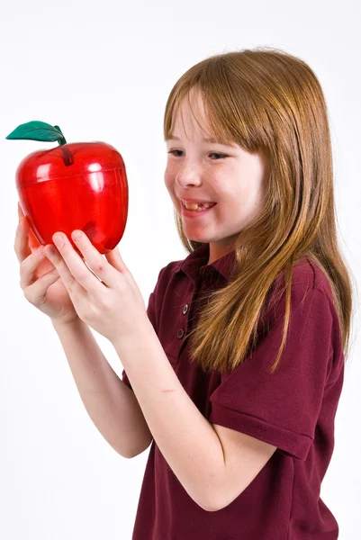 Vrouwelijke school kind houdt van een doorzichtige plastic appel — Stockfoto