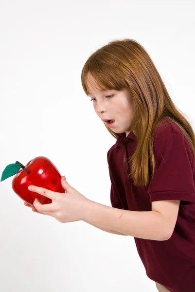 Vrouwelijke school kind houdt van een doorzichtige plastic appel — Stockfoto