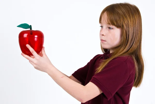 Vrouwelijke school kind houdt van een doorzichtige plastic appel — Stockfoto