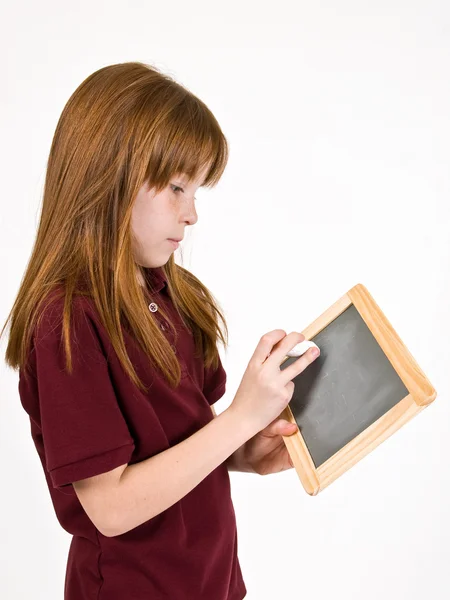 Young girl writing on chalk board — Stock Photo, Image