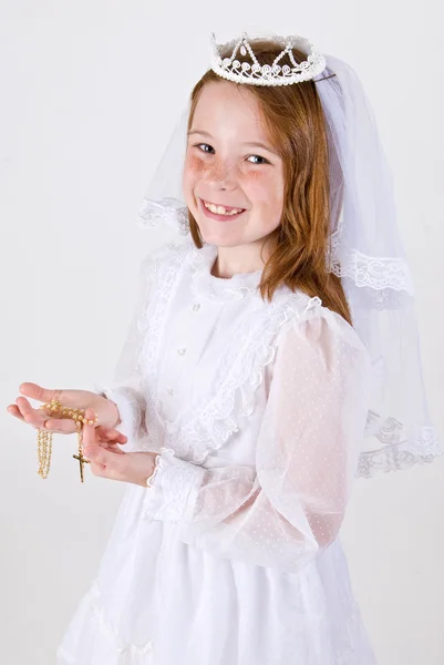 Молодая девушка в своем первом платье причастия — стоковое фото