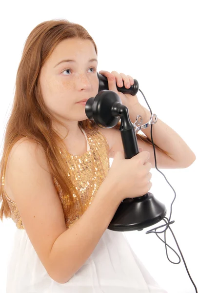 Jeune fille caucasienne dans une robe de fantaisie parler sur un téléphone vintage ou vieux jeu — Photo