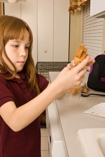 Junges Schulmädchen bereitet gesundes Mittagessen für die Schule zu — Stockfoto