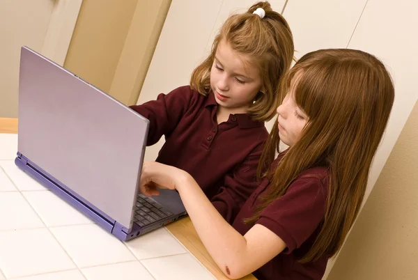 Two young girls working on a laptop computer — Stock Photo, Image