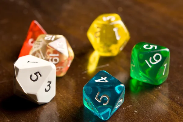 Multicolored Role Play Dice on a wooden table top — Stock Photo, Image