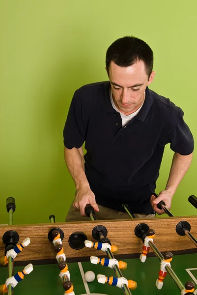 Caucasian male playing Foosball, table football or soccer — Stock Photo, Image