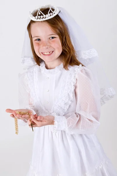 Молодая девушка в своем первом платье причастия Стоковое Изображение