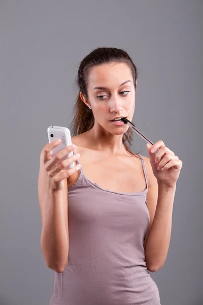 Девушка смотрит на свой мобильный телефон — стоковое фото