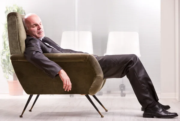 Mature businessman asleep on an armchair — Stock Photo, Image