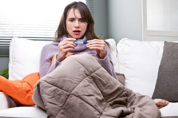 Chica con una mala temperatura en un sofá — Foto de Stock