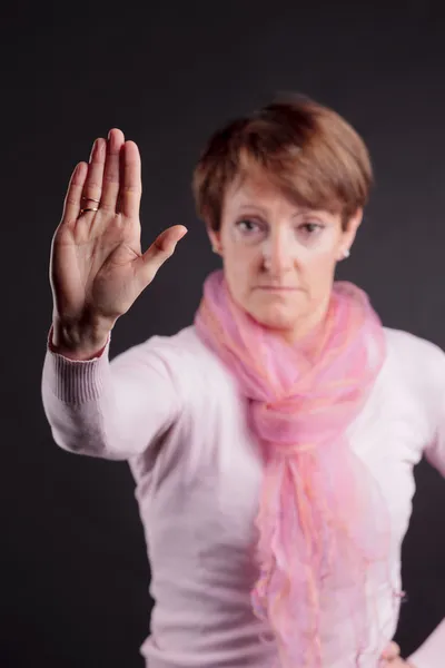Mature woman with a raised closed hand — Stock Photo, Image