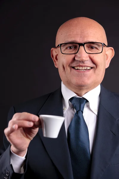 Old businessman with a cup of coffee — Stock Photo, Image