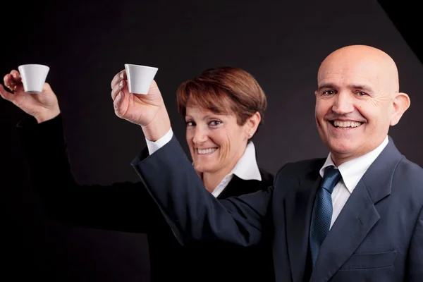 Um casal de idosos segurando duas xícaras de café espreso — Fotografia de Stock